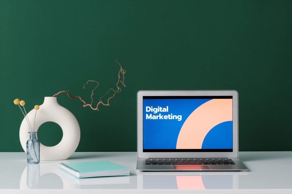 Bureau de travail avec un ordinateur portable affichant les mots "Digital Marketing".