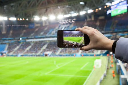 Fan qui prend une photo à un match de football avec son smarthpone