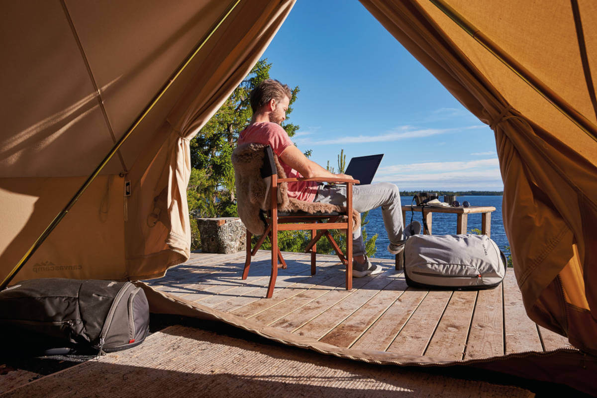 Personne travaillant au bord de la mer sur son ordinateur
