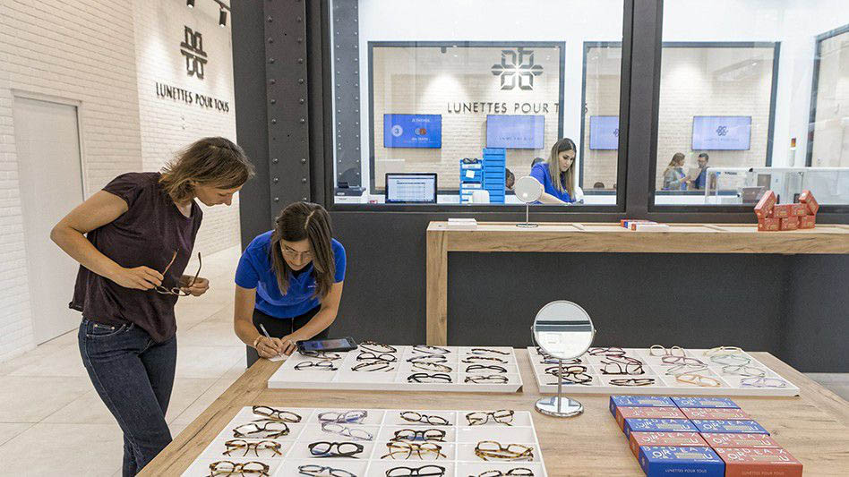 Pour proposer des lunettes à faible prix et en 10 minutes, les magasins Lunettes Pour Tous combinent espace de vente et laboratoire (ou espace de fabrication) visible et identifiable notamment par une différence de lumière.