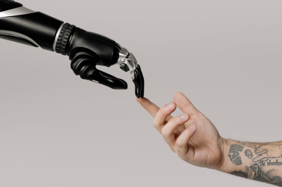 La main d'un robot et celle d'un humain qui se touchent pour former l'intelligence artificielle et les émotions